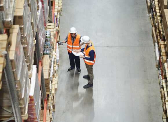2 workers are standing in the factory warehouse