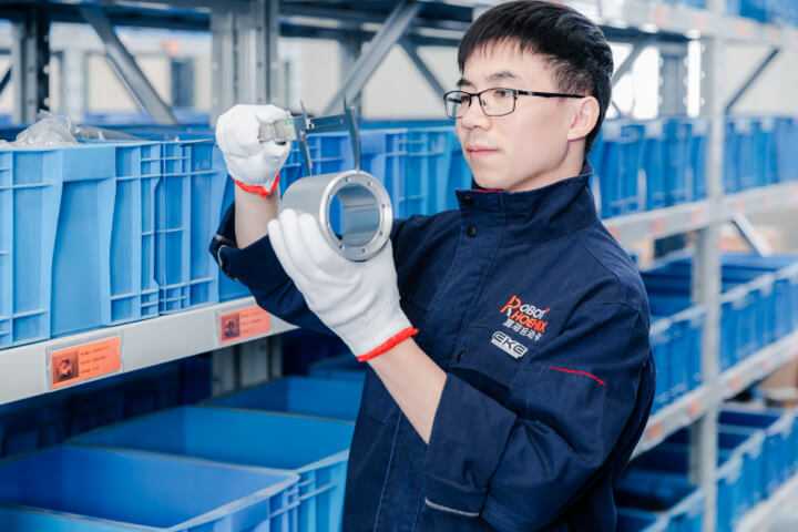 A worker is measuring the component