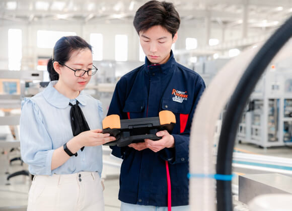 2 people are discussing beside the robot