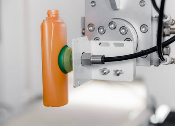 Robot is gripping an orange bottle