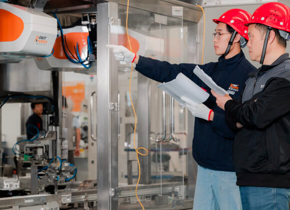 2 men with red helmets are taking the factory acceptance test