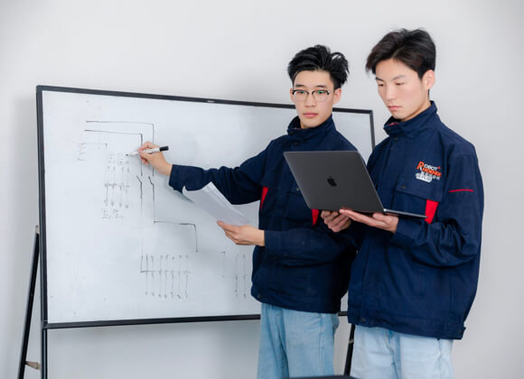 2 men are discussing while writing on the board